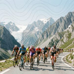Peloton de cyclistes masculins gravissant une route étroite dans un col de haute montagne, avec des sommets rocheux, des glaciers et de discrètes courbes altimétriques abstraites dans le ciel.